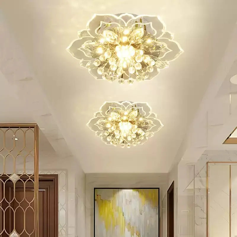 Two gold and crystal floral semi-flush ceiling lights mounted on a white ceiling in a well-lit hallway.