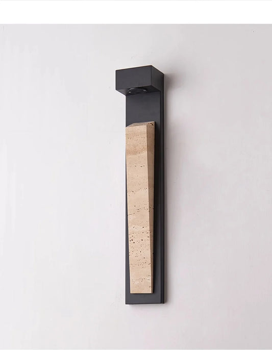 Close-up of a modern black wall sconce featuring a textured natural stone inlay.