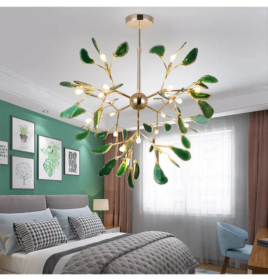 Gold leaf-shaped chandelier with green accents hanging in a bedroom with green walls.