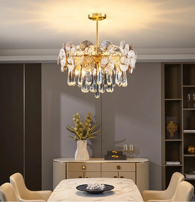 Luxurious chandelier hanging in a modern living room with a table and chairs.