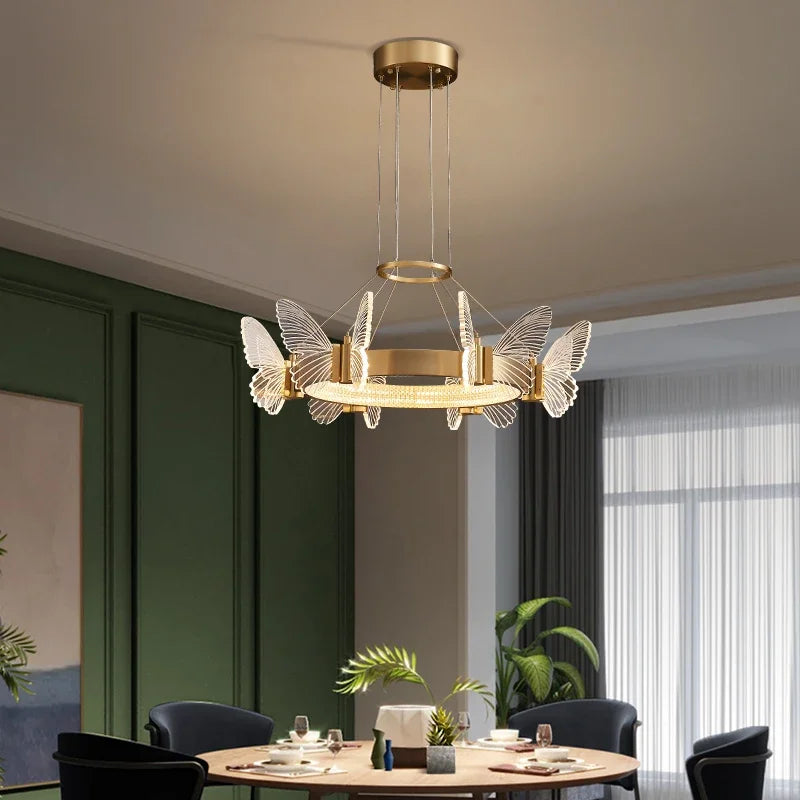 A gold butterfly ring pendant light illuminating a dining room table setting.