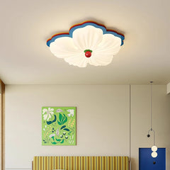 White flower-shaped flush mount ceiling light with multicolor accents in a room with modern art.