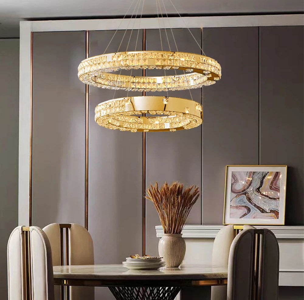 Modern dining room with a gold chandelier, table, chairs, and decorative elements.
