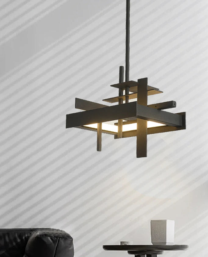 Modern pendant light fixture hanging above a black chair and small table with a white vase against a striped wall.