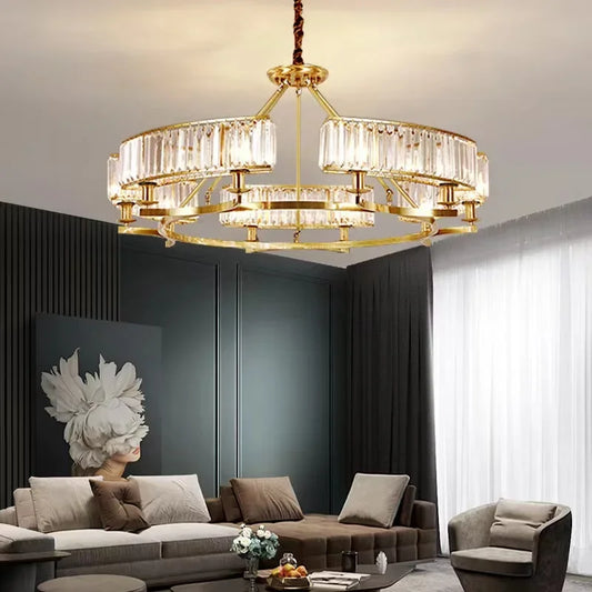 Gold tiered chandelier with crystal accents hanging in a modern living room.