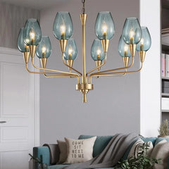 Gold chandelier with blue glass shades hanging in a living room above a sofa.