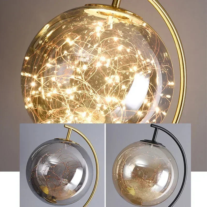 Decorative spherical light fixture with gold frame and clear glass, showing close-up details.