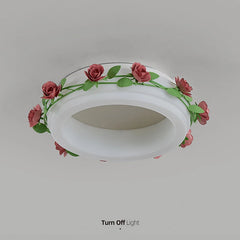 A downward view of a white semi-flush ceiling light adorned with a floral rose vine, shown with the light turned off.