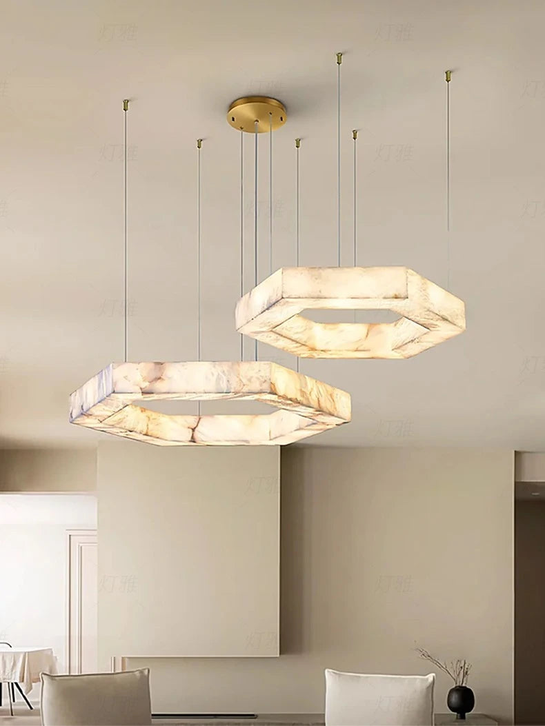 Two modern pendant lights hanging from the ceiling in a room with neutral walls.