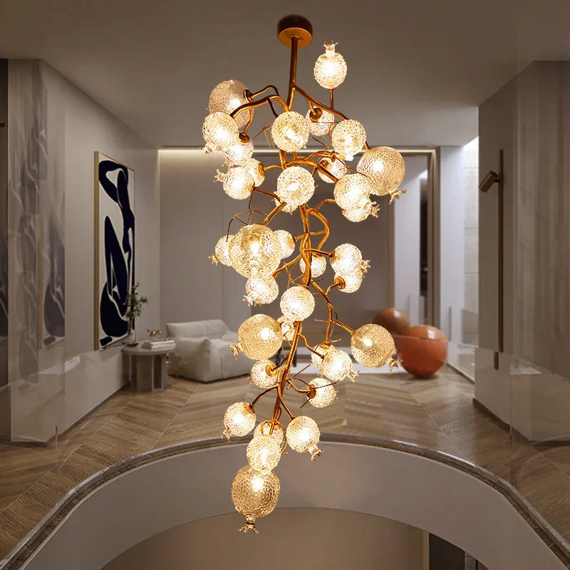 Cascading gold chandelier with crystal globes in a modern interior space.