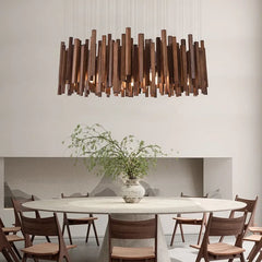 Rectangular wooden stick chandelier with warm lighting above a round dining table