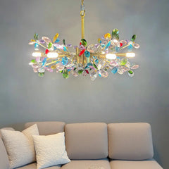 A gold crystal flower chandelier installed above a beige sofa, illuminating the room.