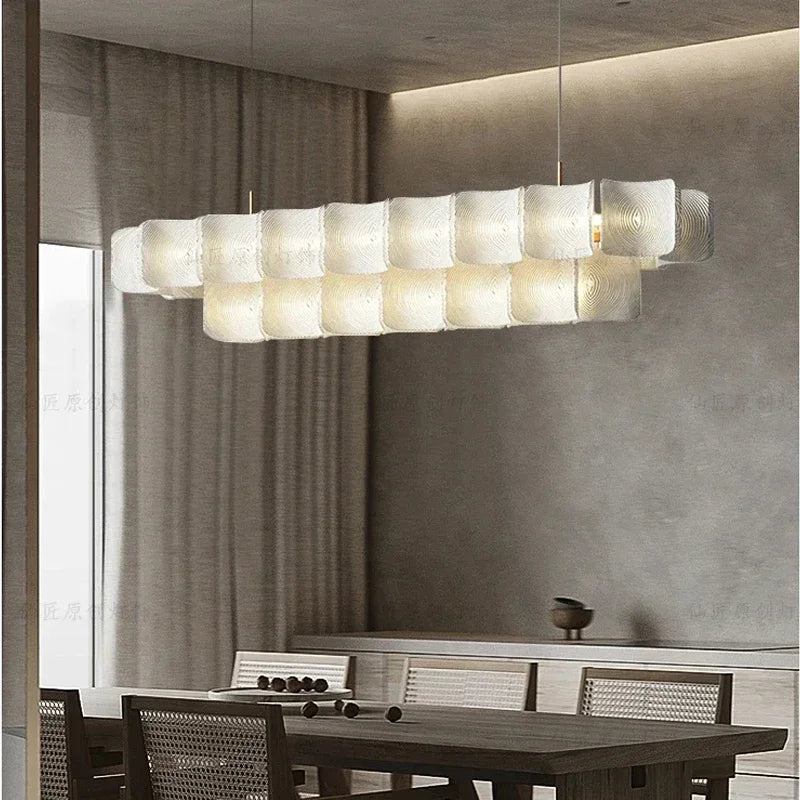 A living room with a gold tiered acrylic wave chandelier as the central light fixture