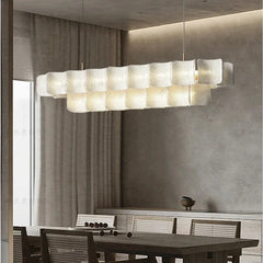 A living room with a gold tiered acrylic wave chandelier as the central light fixture