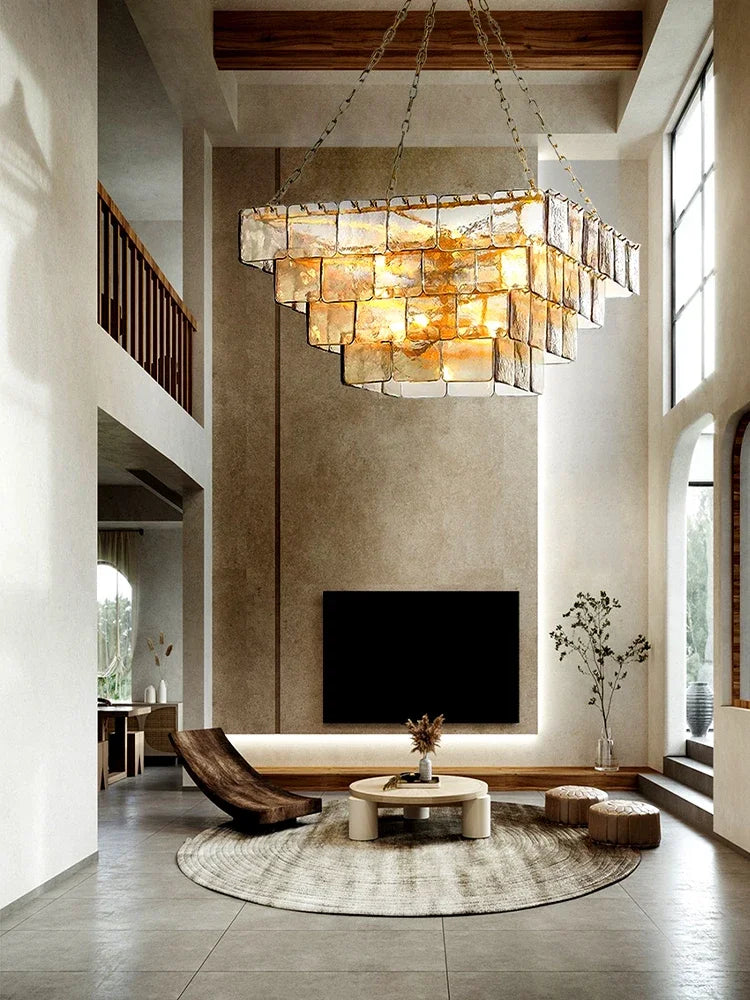 A grand living room featuring a multi-tiered glass and gold chandelier hanging from the ceiling.