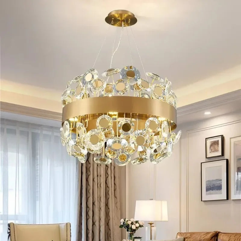 Round gold chandelier with cascading clear and gold-toned crystals, suspended from the ceiling in a living room.