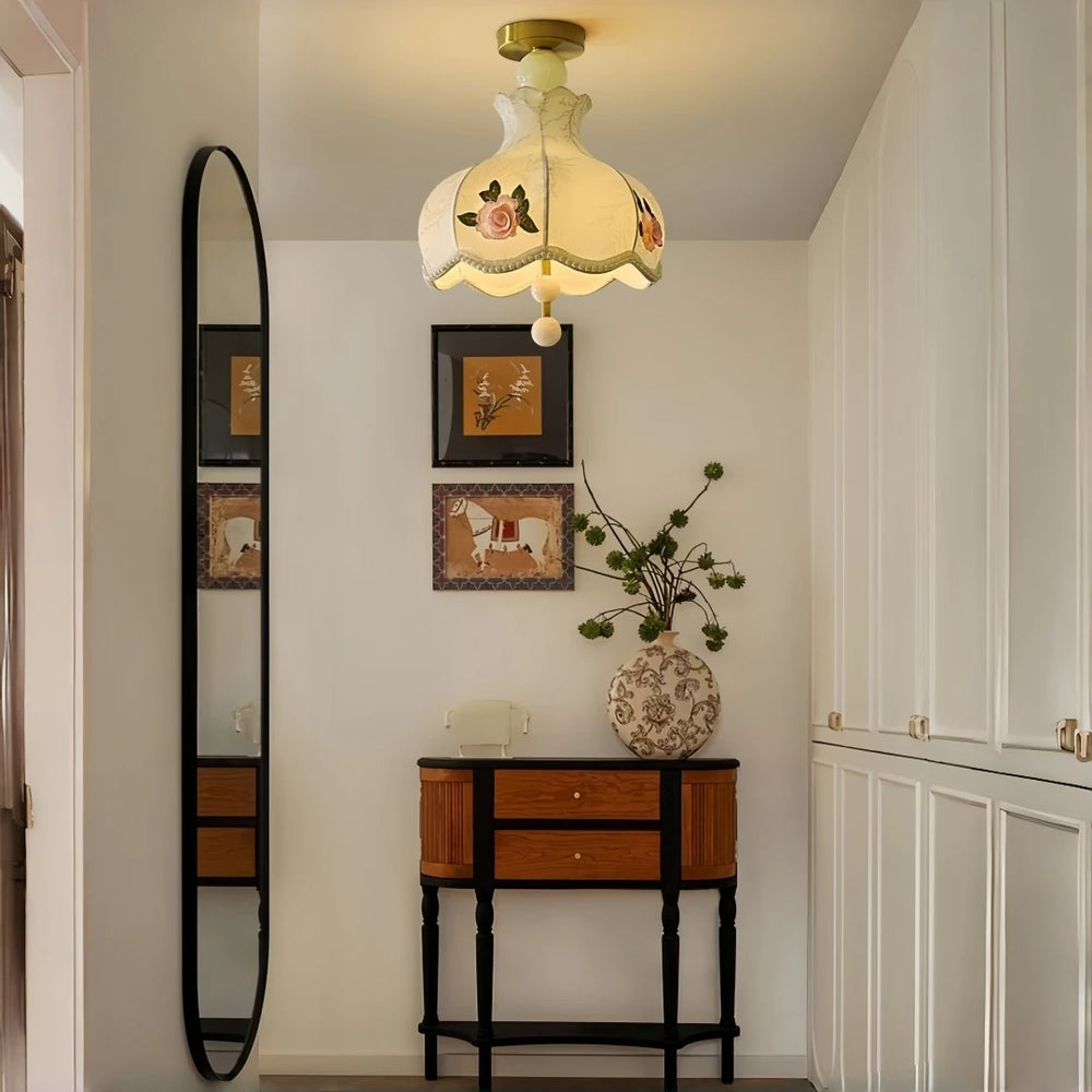 Champagne fabric pendant light with floral rose embroidery hanging in a hallway near a console table and mirror.