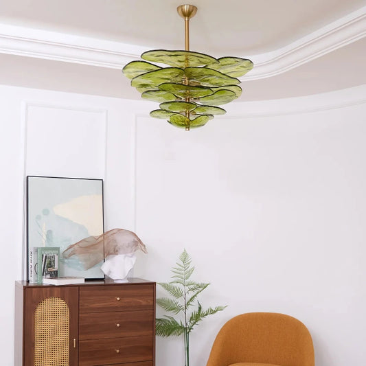 Close-up view of a green glass leaf chandelier, showcasing the layered petal design and polished copper hardware.