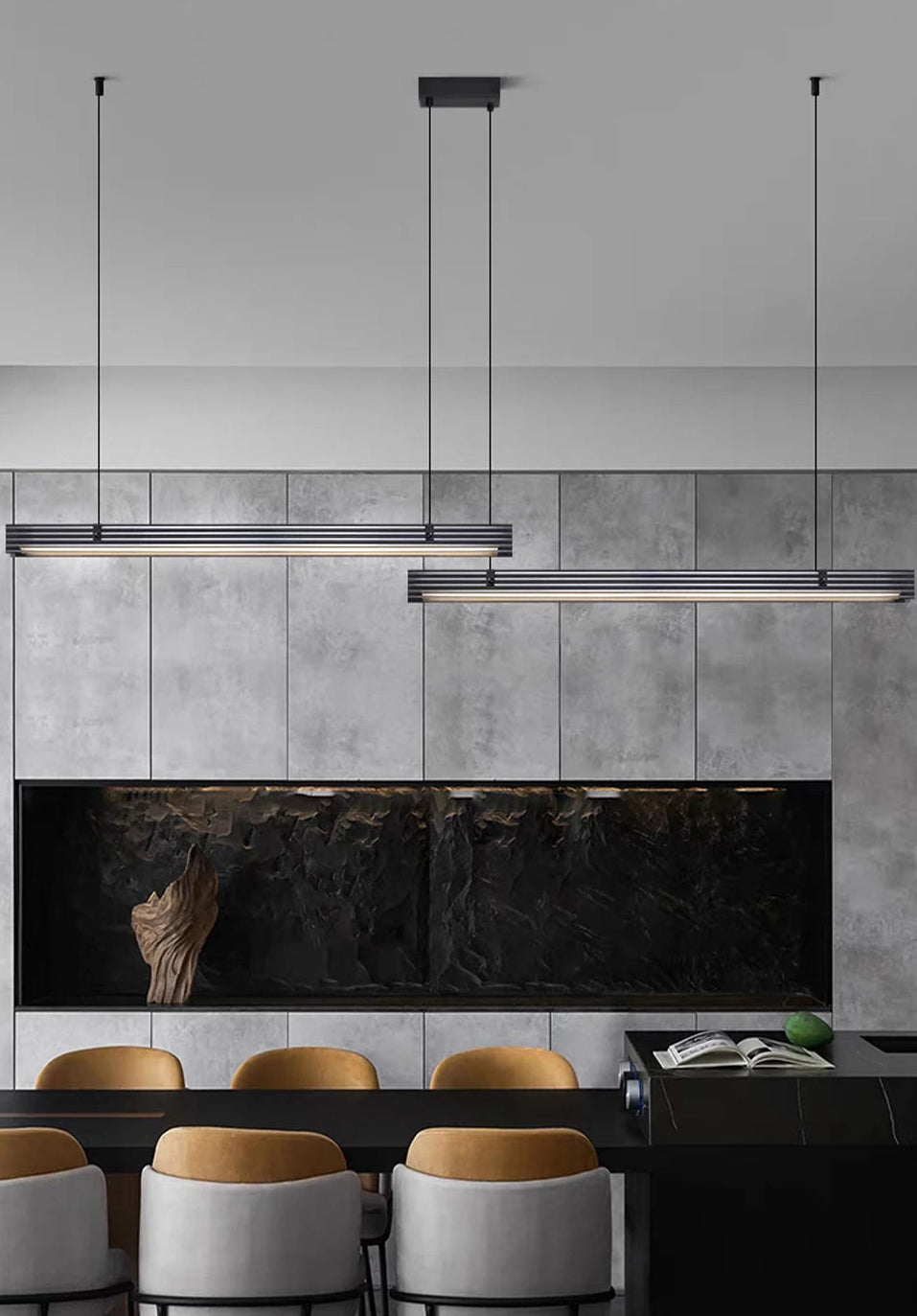 Modern kitchen with pendant lights, gray tiled wall, and wooden dining chairs.