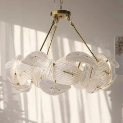 A view of the gold woven floral pendant light showcasing its circular form and the light it casts.