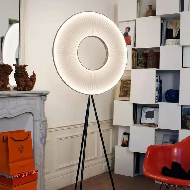 Modern floor lamp with a round, illuminated shade in a stylish room.