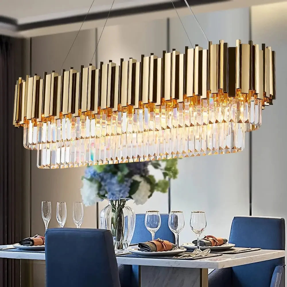 Close-up view of a gold and crystal multi-tier rectangular chandelier illuminating a dining table setting.