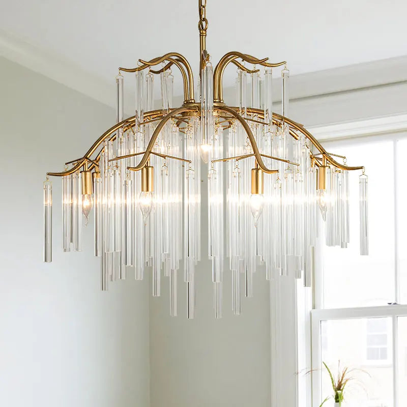 Close-up view of the gold-finished tiered chandelier, showcasing the arrangement of clear glass rods and the central gold frame.