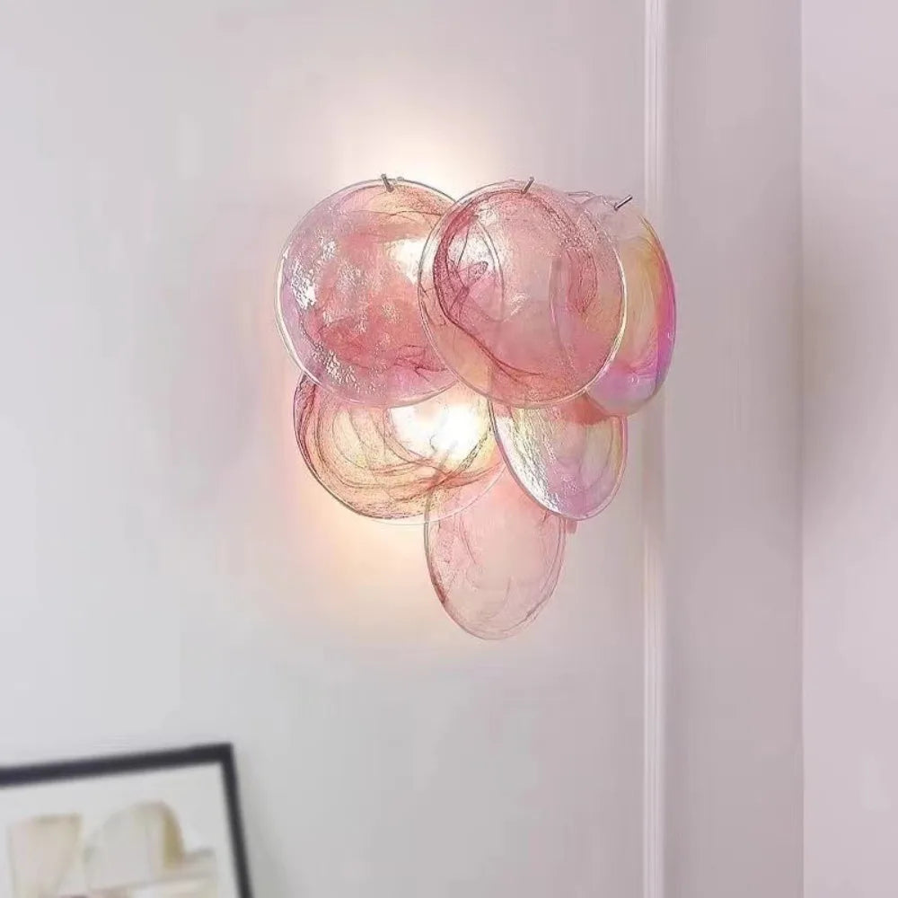 Pink glass wall sconce on a white wall
