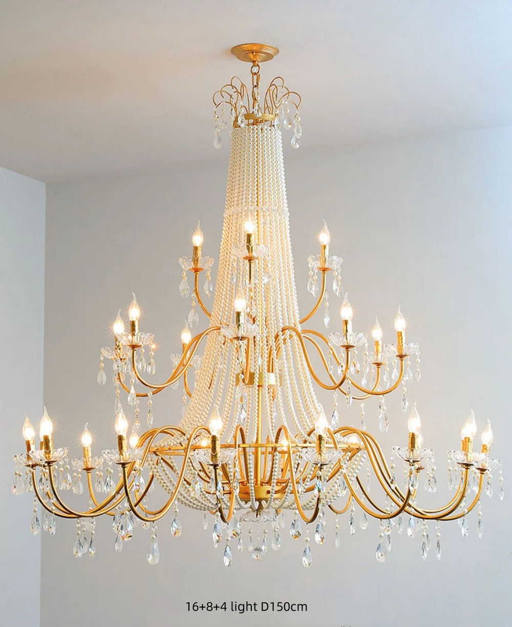 Gold chandelier with crystal accents against a white wall