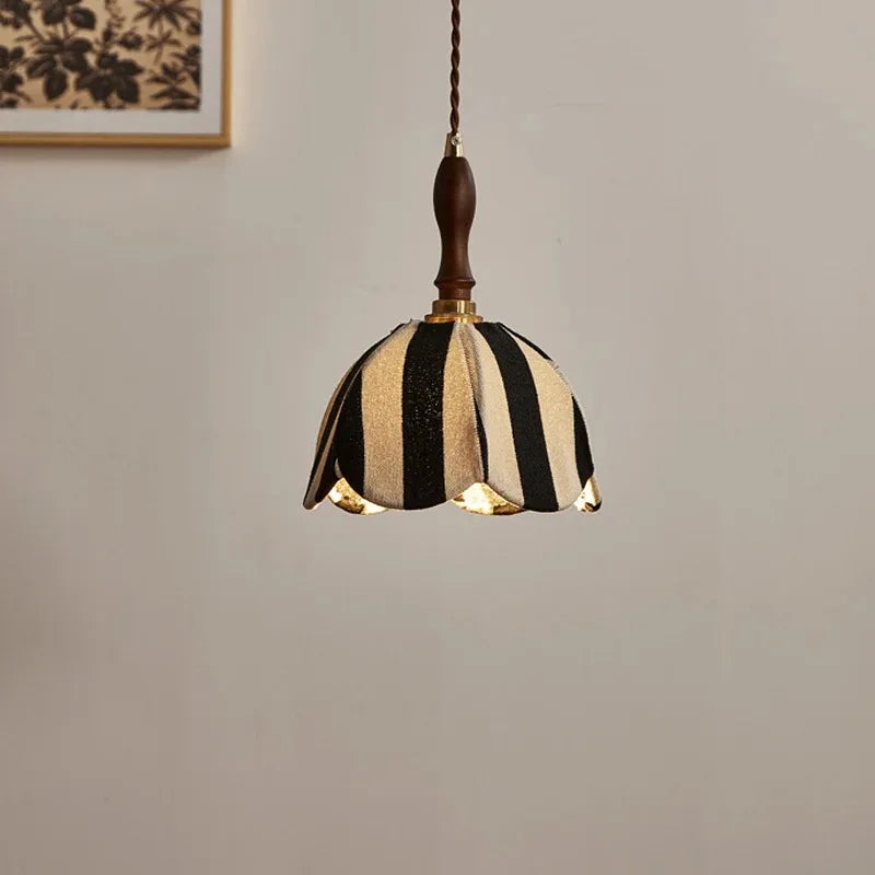 The pendant light is shown from a slightly different angle, revealing the warm glow emanating from the bottom of the shade.