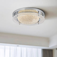 Angled view of a chrome flush mount light, highlighting the textured glass and polished metal elements.