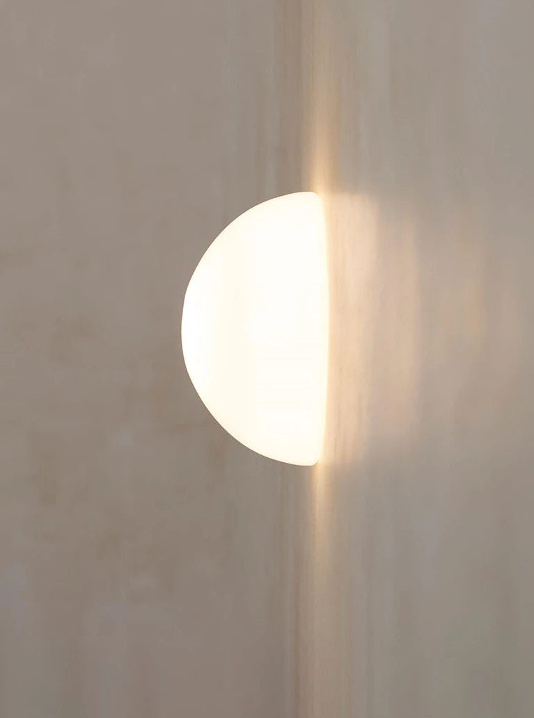 Spherical light fixture casting a shadow on a textured wall