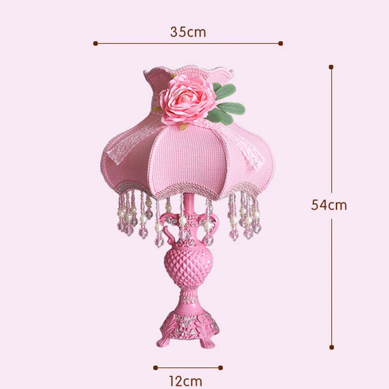 Pink decorative table lamp with floral design and measurements on a white background