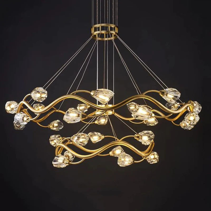 Full view of the gold wavy crystal chandelier against a dark background, showcasing its elaborate structure and crystal embellishments.