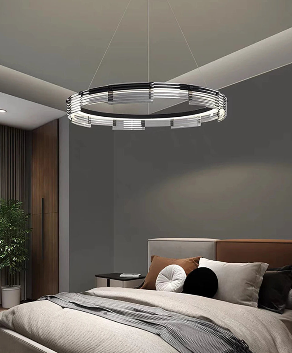 Modern chandelier hanging above a bed in a bedroom setting