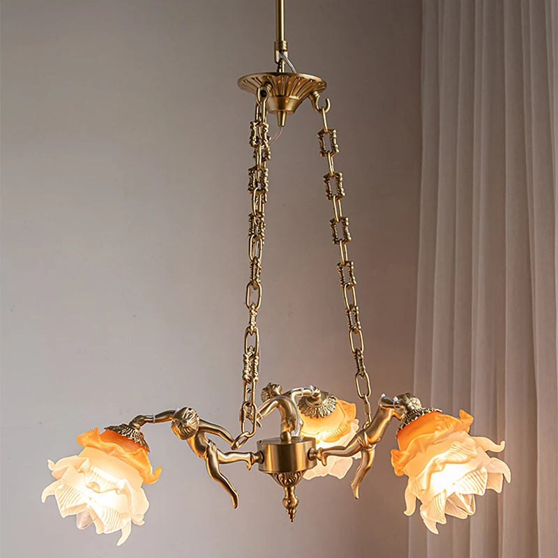 A close-up view of the central part of a copper chandelier, showing the connection of chains, angel figures, and flower shades.