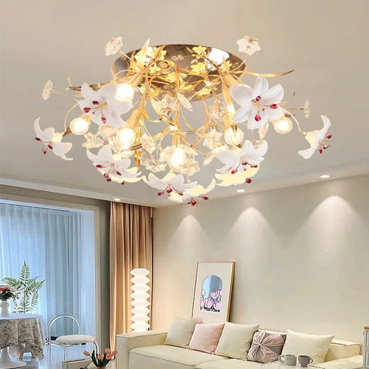 Close-up of the gold floral chandelier with white ceramic petals and red accents