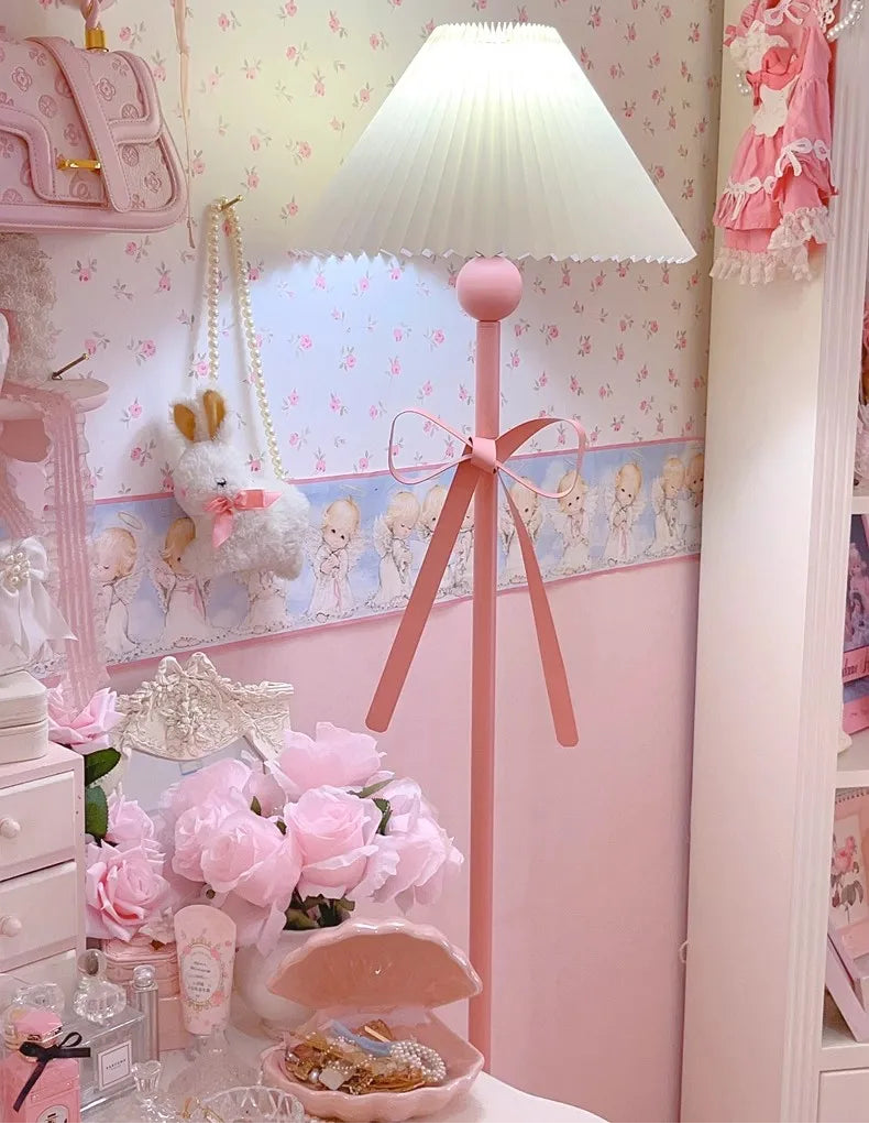 Pink floor lamp in a child's bedroom with decorative wallpaper and toys.