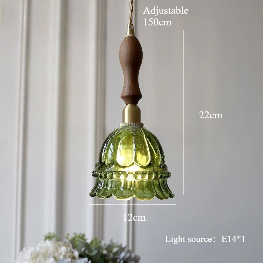 Green pendant light with wooden handle and measurements on a neutral background