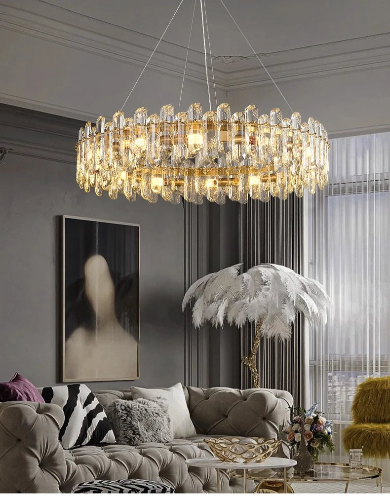 Interior scene showing a gold crystal chandelier hanging above a sofa, with a modern painting and a floor lamp nearby.