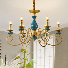 A wider view of the gold candelabra chandelier with teal ceramic accents illuminating a room.