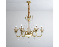 Close-up view of the gold chandelier's arms and central column, showcasing intricate detailing and crystal droplets.