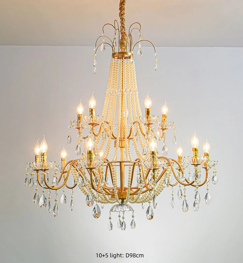 Gold chandelier with crystal accents on a plain background