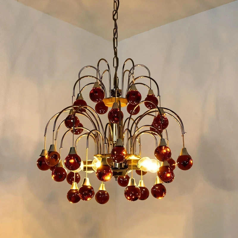 A red droplet crystal chandelier with a gold frame, showcasing its tiered design.