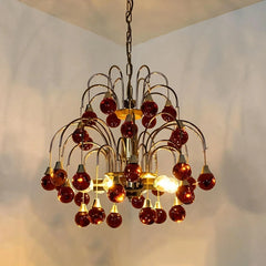 A red droplet crystal chandelier with a gold frame, showcasing its tiered design.