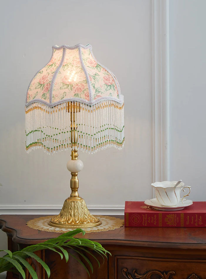 Decorative lamp with floral lampshade on a wooden table.