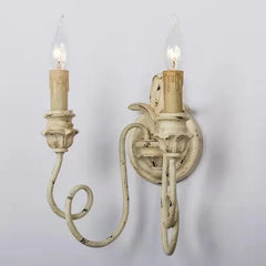 Vintage-style wall sconce with two candles on a plain background