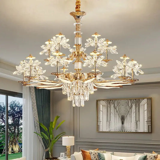 A close-up of a gold chandelier with crystal flower accents and cascading teardrop crystals hanging from a ceiling.