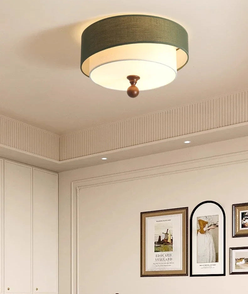 Ceiling light fixture in a room with framed pictures on the wall.