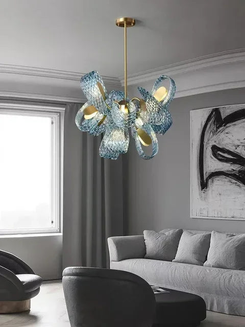 Modern chandelier in a living room with gray walls and a sofa.